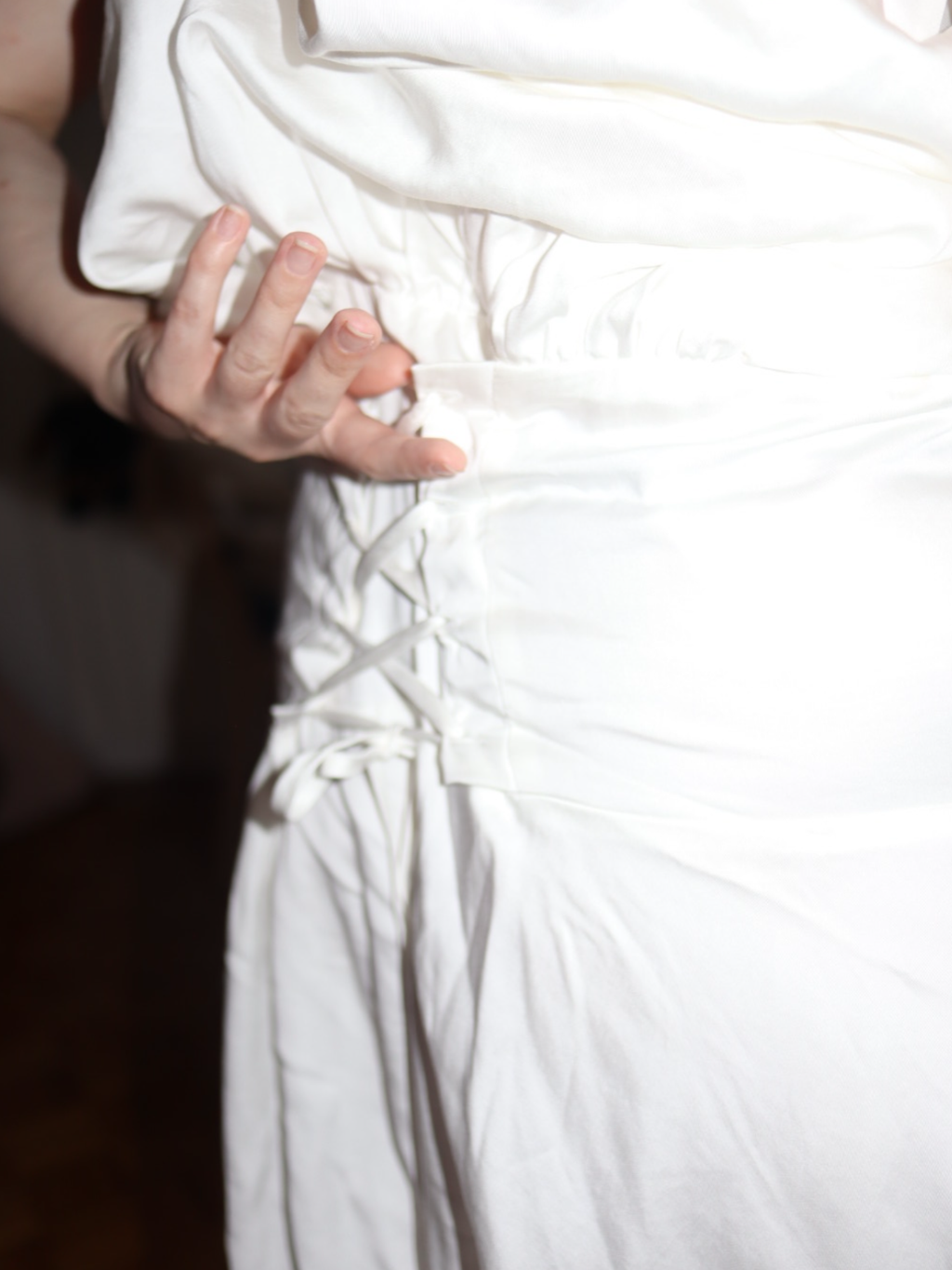 Close-up of a hand holding a white fabric with a blurred background